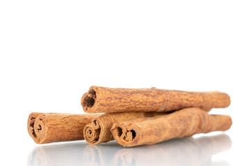 Several fragrant dry cinnamon sticks, close-up, isolated on white.