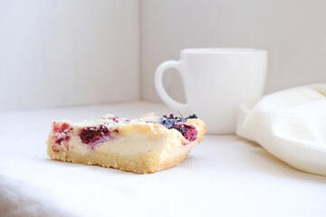 Neutral modern simple minimalistic food template. Homemade cheasecake with berries and white mug on a gray natural napkin. Original bakery. Empty space. 