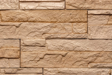 Beige tiled wall with a three-dimensional, roughened surface for use as abstract backgrounds and textures.