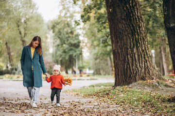 Fototapeta premium Young mother with her little daughter in an autumn park