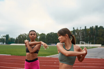 Women stretching before run training on stadium