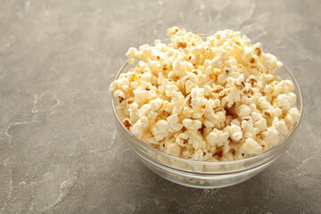 Fresh popcorn in bowl on grey table with copy space