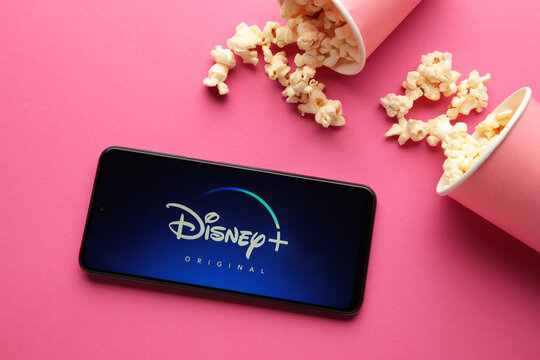 Nikolaev, Ukraine - November 20, 2021. Movies and series by subscription, concept. smartphone with Disney plus logo on pink background