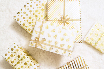 Christmas gifts boxes wrapping  in white gold paper for family lying on fluffy snow-white carpet. Top view