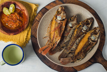 Fried Tilapia fish with cantella asiatica and hot and spicy sauce as side dish against white background