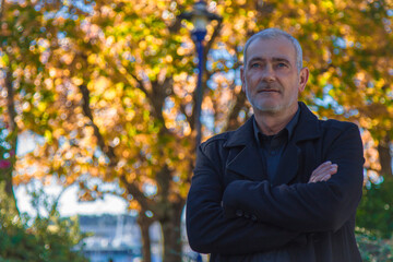 man in coat posing in autumn background