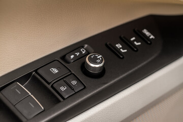 Obraz premium Side mirrors control panel on side door. Car driver adjust side mirror controller. Side mirror control button for adjusting the side mirrors.