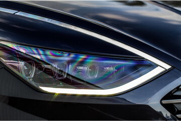 Headlight lamp of new car. Close up detail on one of the LED headlights modern car. Exterior...