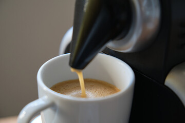Close up of a coffee machine pouring an expresso in a cup.