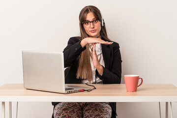 Young caucasian woman doing telecommuting isolated on white background showing a timeout gesture.
