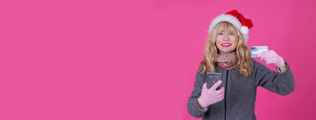 woman with santa claus hat with mobile phone and credit card shopping online