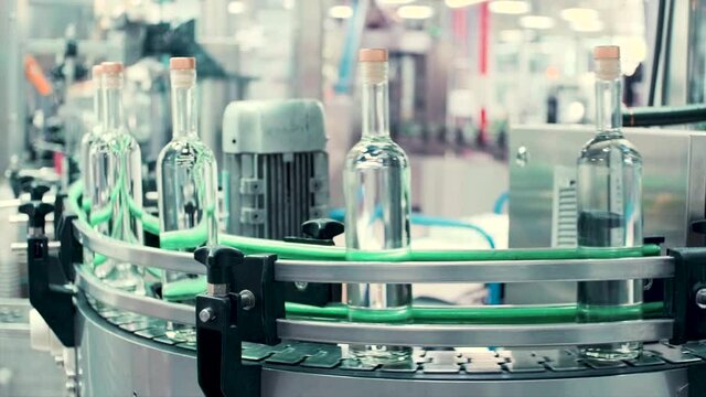 A conveyor with bottles. Clip. Production of glass bottles and draught drinks at the factory.