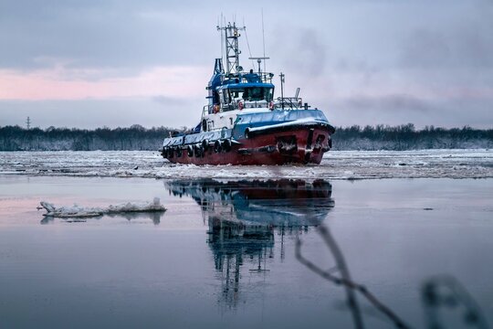 Tugboat ship on the river among the ice. Northern Navigation, Russia, Arkhangelsk