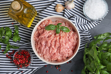 Raw chicken minced meat and ingredients on black table, flat lay