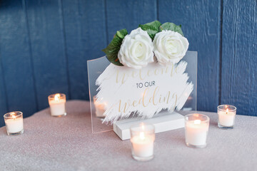 Transparent wedding sign with words welcome to our wedding with two white roses on it An invitation...