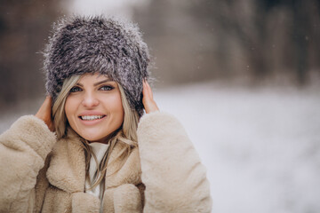 Beautiful woman walking in park full of snow