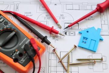 a screwdriver with a gauge and a toy house on a circuit diagram