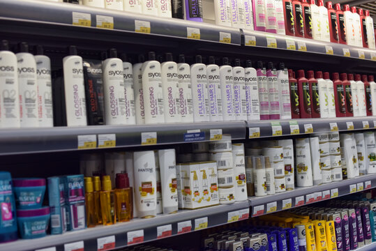 Shampoos and hair products on a shelf in a supermarket