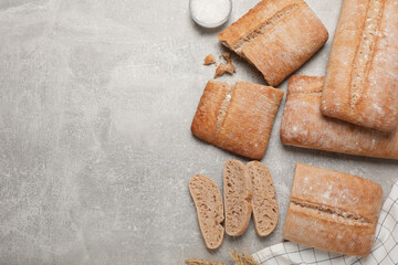 Fresh crispy ciabattas on grey table, flat lay. Space for text