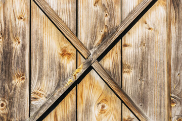 Grunge wooden barn door. X shape wooden desks. Rustic vintage desk construction background....