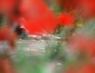 sexy young brunette woman lies dead after accident or crime on path in garden surrounded by many...