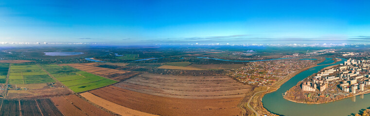 the Yubileiny microdistrict of the city of Krasnodar on the bend of the Kuban River and the rice fields of the Adyghe coast - a large aerial panorama on a sunny day in late autumn