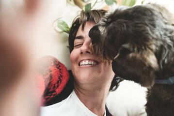 Happy girl doing selfie with dog having fun and licking her face - Love and pet friendship