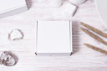 Top view, white cardboard box on wooden desk, mock up