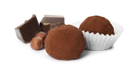 Delicious chocolate truffles with ingredients on white background