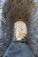 Fototapeta na wymiar Empty path covered with arch stonewall shelter at Vathia Mani Laconia Peloponnese Greece. Vertical