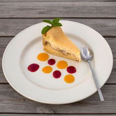 a piece of delicious fresh cake on a large plate with colorful jam drops