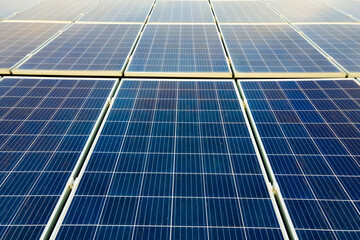 Closeup of surface of blue photovoltaic solar panels mounted on building roof for producing clean...