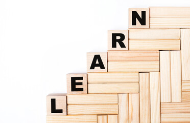 On a light background, wooden blocks and cubes with the text LEARN