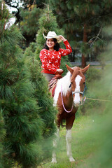 Mujer a caballo con suéter navideño en bosque