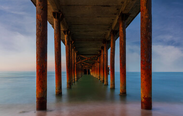 Pier leaving the sea at sunset