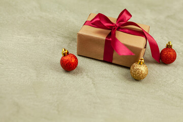 Fototapeta na wymiar Wrapped vintage gift box with red ribbon bow, beige factrun background
