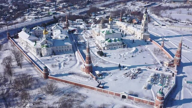 Aerial view in winter of the old Epiphany Staro-Golutvina monastery on the outskirts of the city of Kolomna and residential areas in the distance, Russia. 