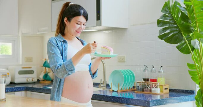 Asian pregnant woman eat cake