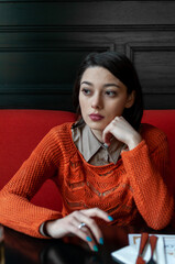 Portrait of a woman in a red sweater sitting by a table