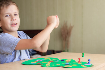 child rolls the dice and moves the chip across the Christmas playing field