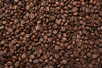 Pile of roasted coffee beans as background, top view
