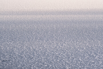 Fototapeta na wymiar Texture of ice of frozen lake in sunlight