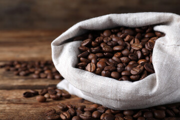 Bag of roasted coffee beans on wooden table, closeup