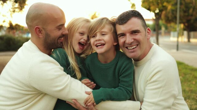 LGBT family outdoor - Happy gay men fathers and sons having fun together at city park