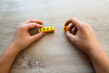Hands holding yellow cubes 2021 and 1, copy space. Start new year 2022 with goal plan, goal...