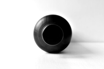 Black cork of black bottle close up on blurred white background in natural light on table