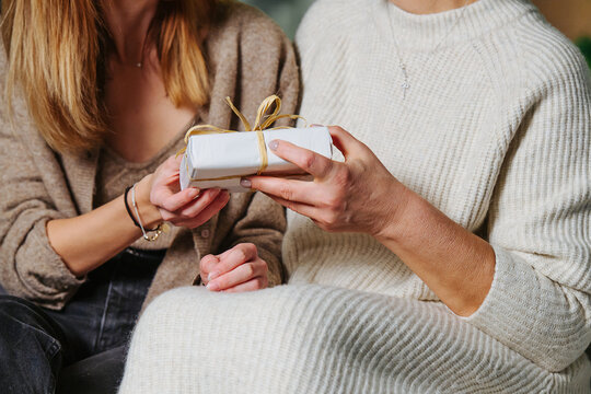 Close up view of a grandma recieving christmas present from her adult daughter