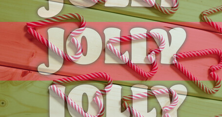 Image of jolly text on red and green stripes over christmas candy canes