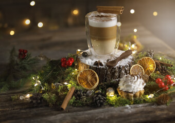 Festive latte in a glass cup with tartlet on the dark wooden background
