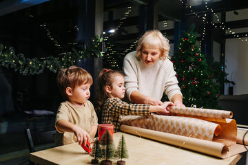 Patient grandmother and children talking about how to wrap a present.